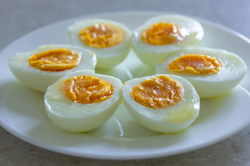 Boiled eggs with butter on white plate put as shape of flower