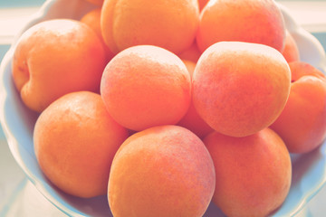Organic dried fresh apricots in white bowl in vintage style