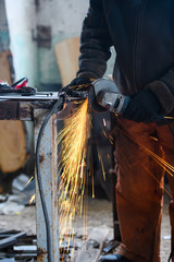 Metal grinding on steel pipe with flash of sparks close up