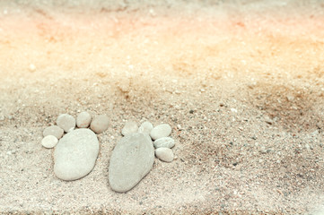 Fototapeta na wymiar maritime background with feet made of stones on sand background