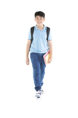 Smiling little student boy in blue polo t-shirt in with books and bag.