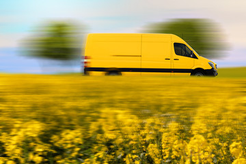 Fast parcel delivery, yellow mail van on country road.