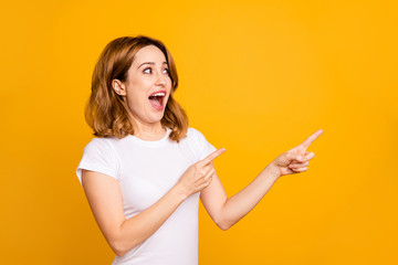 Close up photo beautiful amazing she her lady look unbelievable unexpected arms hands fingers indicate empty space look what I have short hairdo wear casual white t-shirt isolated yellow background