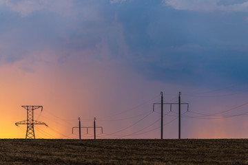 Fototapeta na wymiar Epic sunset with rural landscape with high-voltage line