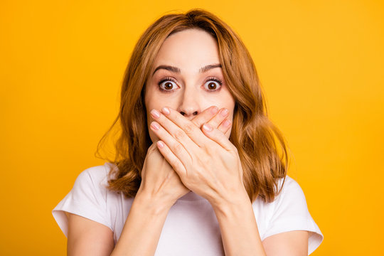 Close up photo beautiful amazing she her lady  hold arms hands fingers hiding lips mouth eyes full fear wrong bad awful situation short hairdo wear casual white t-shirt isolated yellow background