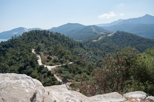 view of the forest road and mountains from a high cliff
