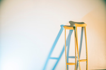 crutches stand at the light wall as a symbol of disability and injury