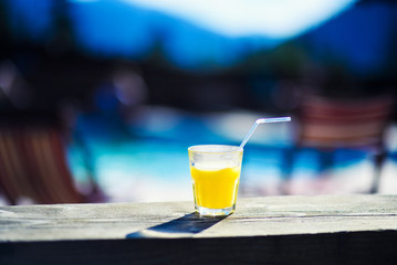 Fresh orange juice in glass on mountain landscape background