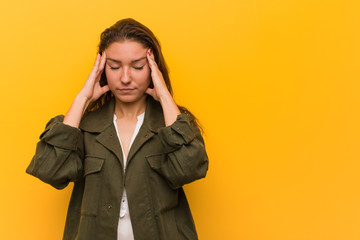 Young european woman isolated over yellow background touching his temples and having headache.