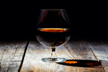 glass with cognac on a wooden background