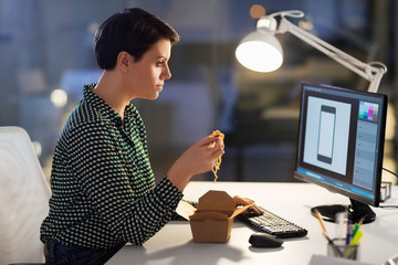 business, deadline and people concept - female graphic designer eating takeaway wok food by...