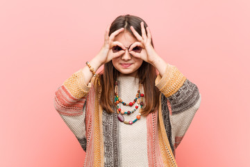 Little hippie girl showing okay sign over eyes