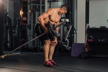 Young muscular man in the gym doing exercise