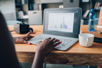 Close up of young businesswoman working on laptop in office