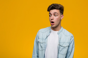 Obraz premium Young handsome student wearing a denim shirt being shocked because of something she has seen.
