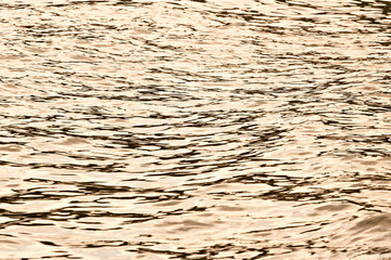 Sea surface texture. Yellow sunset color.