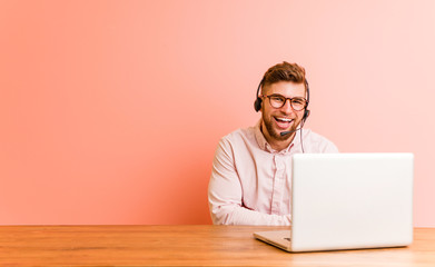 Young man working in a call center laughing and having fun.