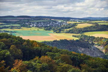 Fototapeta na wymiar View to hills and fields of Rheinland-Pfalz state with village from tourist route on Hessen state