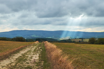 Autumn agriculture field with ray of light from clouds