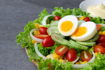 Healthy vegetables salad with boiled egg in wooden dish on table for vegetarian.