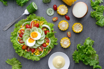 Healthy vegetables salad with boiled egg in wooden dish on table for vegetarian.