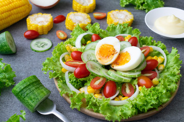 Fototapeta na wymiar Healthy vegetables salad with boiled egg in wooden dish on table for vegetarian.