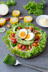 Healthy vegetables salad with boiled egg in wooden dish on table for vegetarian.