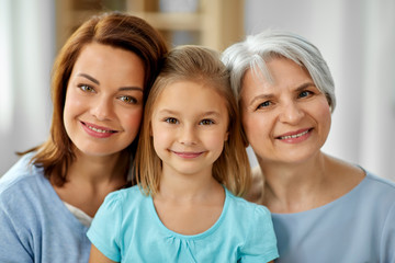 family, generation and female concept - portrait of smiling mother, daughter and grandmother at home