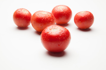 Tomate, rojo, sano con gotas de agua sobre fondo blanco