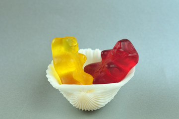 red and yellow gummy bear in cockle shell
