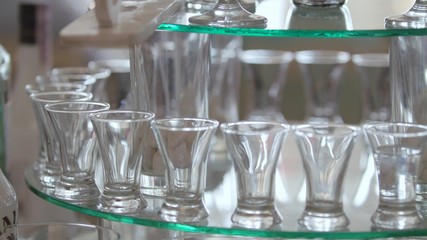 Alcoholic Paradise. The man's hand pours an alcoholic beverage. On the table, a lot of dishes in which pour a drink. Slow motion