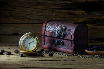 Old pocket watch and Treasure Chest on dark wood, still life