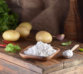 potato starch in a wooden bowl on a wooden background