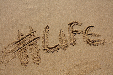 hashtag written by hand in the sand