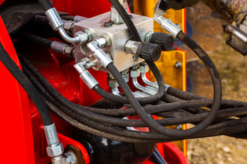 Close up of pipe system of hydraulic valves in agricultural machinery