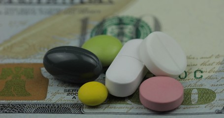Medical pills and tablets on dollar banknote. Pharmaceutical business concept