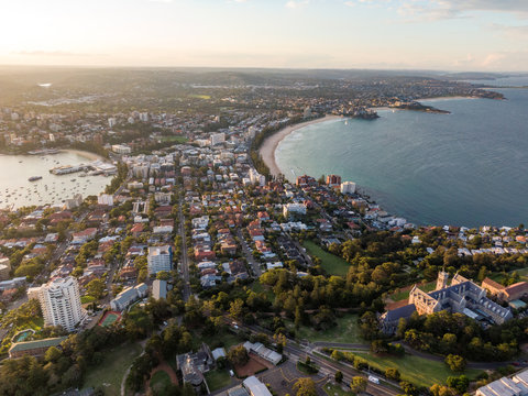 Panoramic Evening Aerial Drone Shot Of Manly, A Beach-side Suburb Of Northern Sydney, In The State Of New South Wales, Australia With The Historic Management College In The Foreground.