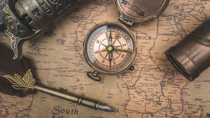 Vintage Compass And Quill Pen On Old World Map