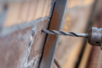 drilling holes in a brick wall close up