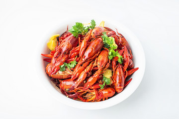 A large bowl of bright red delicious braised crayfish on a white background