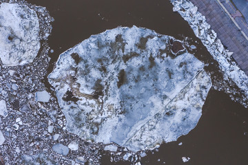 Aierial view from the top down on ice floes floating on the river.