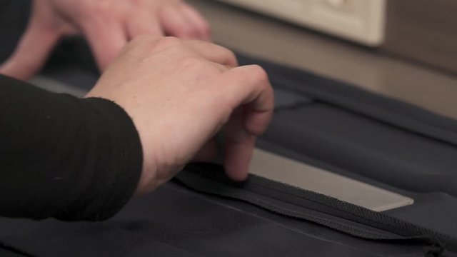 A close-up video of a professional tailors hands measuring the material and preparing it for cutting.