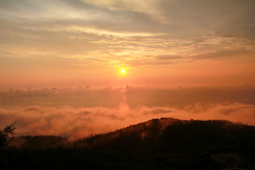 Beautiful structure of clouds on sky, mountain landscape with dense fog at sunset on horizon of beauty natural environment. Panorama of amazing sunrise view show sun rays through clouds over mountain.