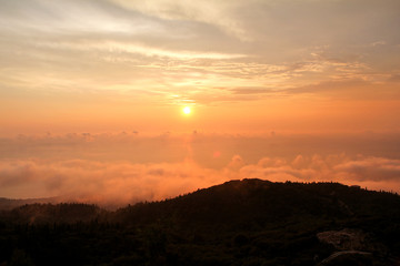 Beautiful structure of clouds on sky, mountain landscape with dense fog at sunset on horizon of beauty natural environment. Panorama of amazing sunrise view show sun rays through clouds over mountain.