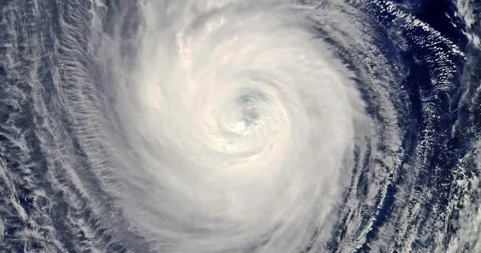 Satellite view over the eye of a hurricane as it rotates continuously.