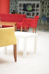 Red and yellow chairs, table in modern interior. Elelenta interior.