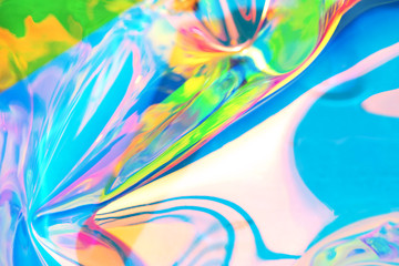 Fototapeta premium Holographic iridescent surface. Copy space. Bright colorful hologram background. Wrinkled abstract texture with multiple colors. Neon surface.