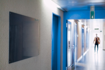 Man walking through a hospital corridor, defocus