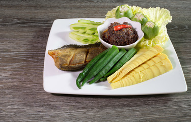 Fried chili paste, eaten with vegetables and fried fish, (thai language  nam prik pao) in white dish on wooden table thai food