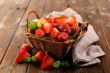 strawberry and mint in basket on wood background